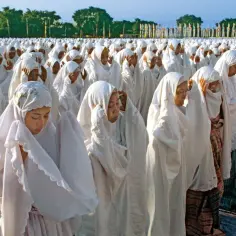 Tysiące kobiet w białych hidżabach modlą się, oddając cześć islam religia.