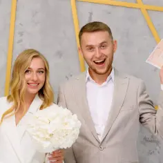 Szczęśliwa para młoda trzyma dokumenty. Czy bierzmowanie jest potrzebne do ślubu? Nie, liczy się miłość i dokumenty!