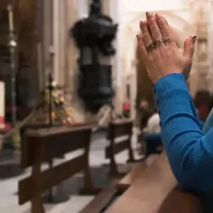 Dłoń w geście modlitwy, symbol głębokiej dewocji w kościele.