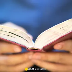Dłonie trzymają otwartą księgę, być może zawierającą 10 przykazań bożych dekalog.