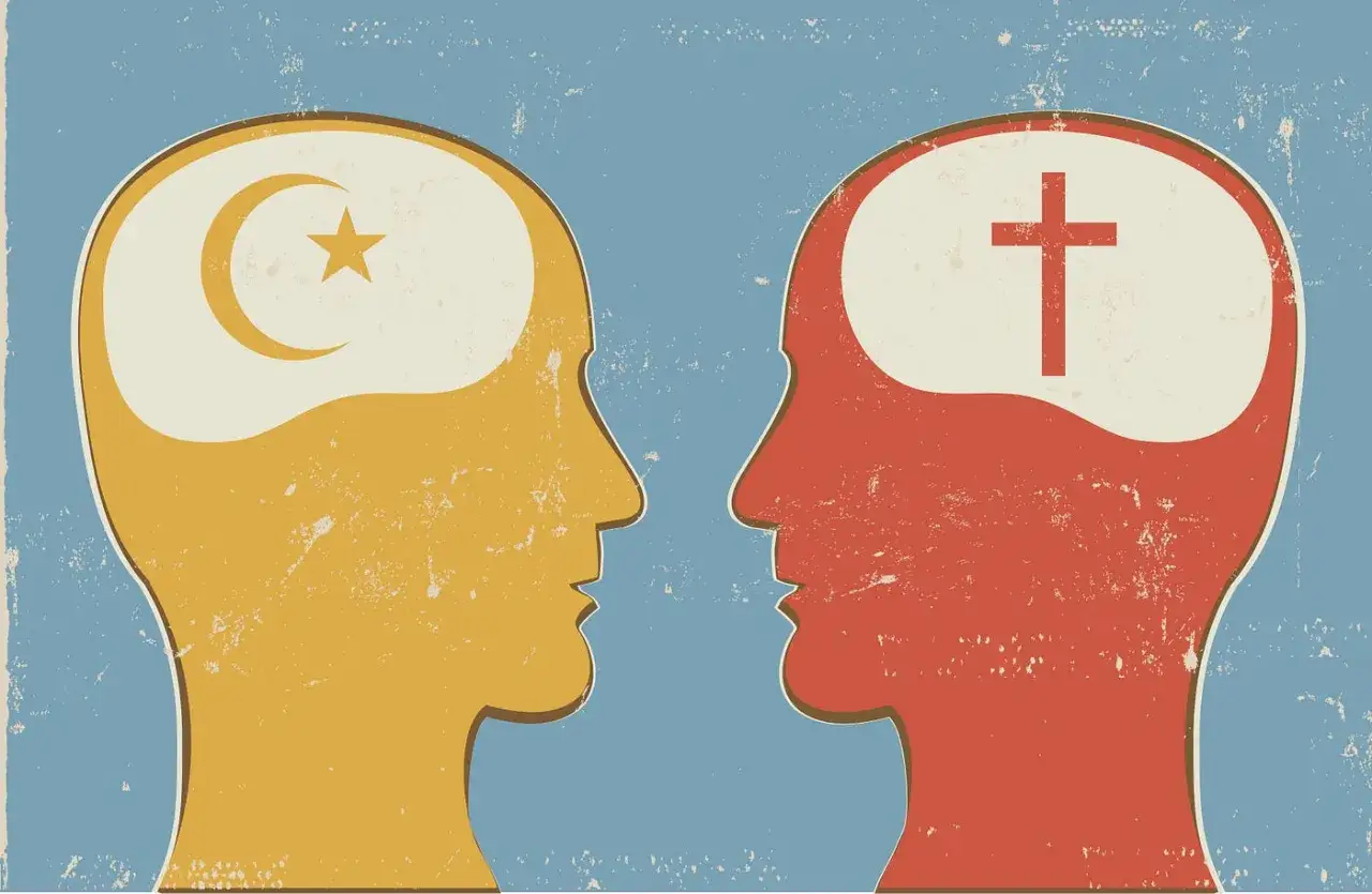 Dwie głowy, jedna z półksiężycem i gwiazdą (islam), druga z krzyżem (chrześcijaństwo), symbolizują dialog międzyreligijny.