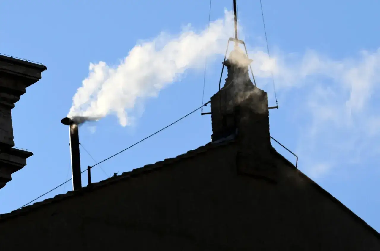Biały dym z komina na tle błękitnego nieba. Czyżby habemus papam?