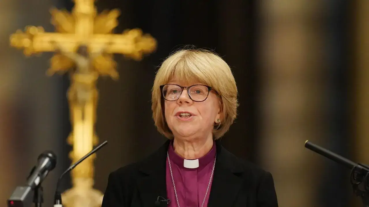Arcybiskup Canterbury przemawia przed złotym krzyżem.